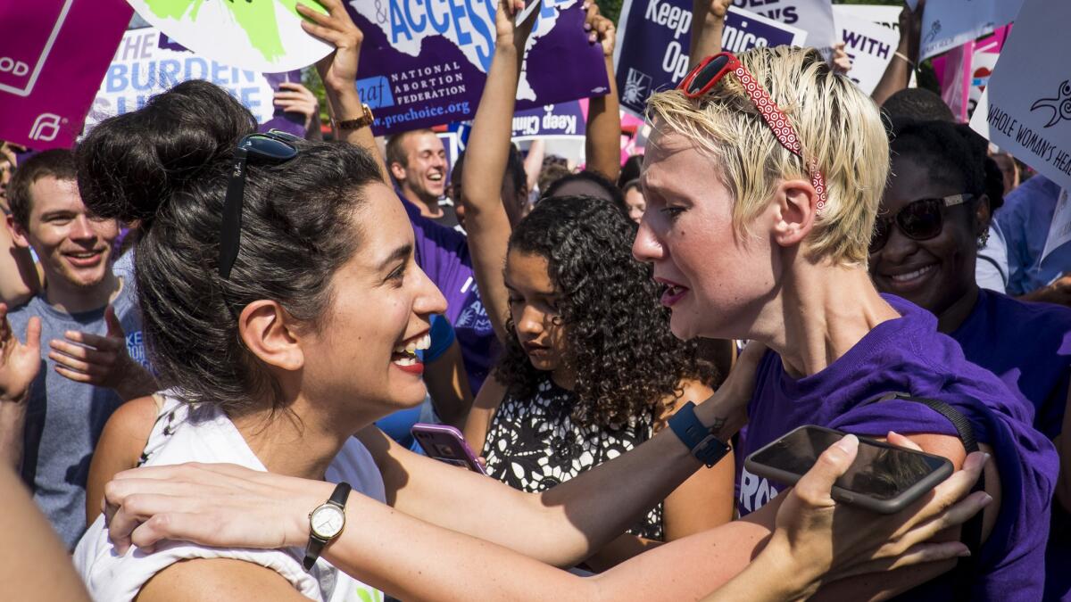 Abortion rights activists Morgan Hopkins of Boston, left, and Alison Turkos of New York celebrate on the steps of the U.S. Supreme Court in Washington, D.C., on June 27, 2016.