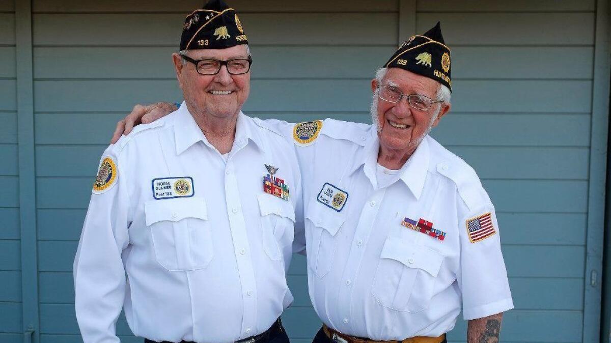 Marine Corps veteran Norm Sumner, 77, left, and Navy veteran Bob Laizure, 93, both of Huntington Beach, are among seven Purple Heart recipients selected to ride aboard the Odd Fellows and Rebekahs float during the Rose Parade in Pasadena on New Year’s Day.
