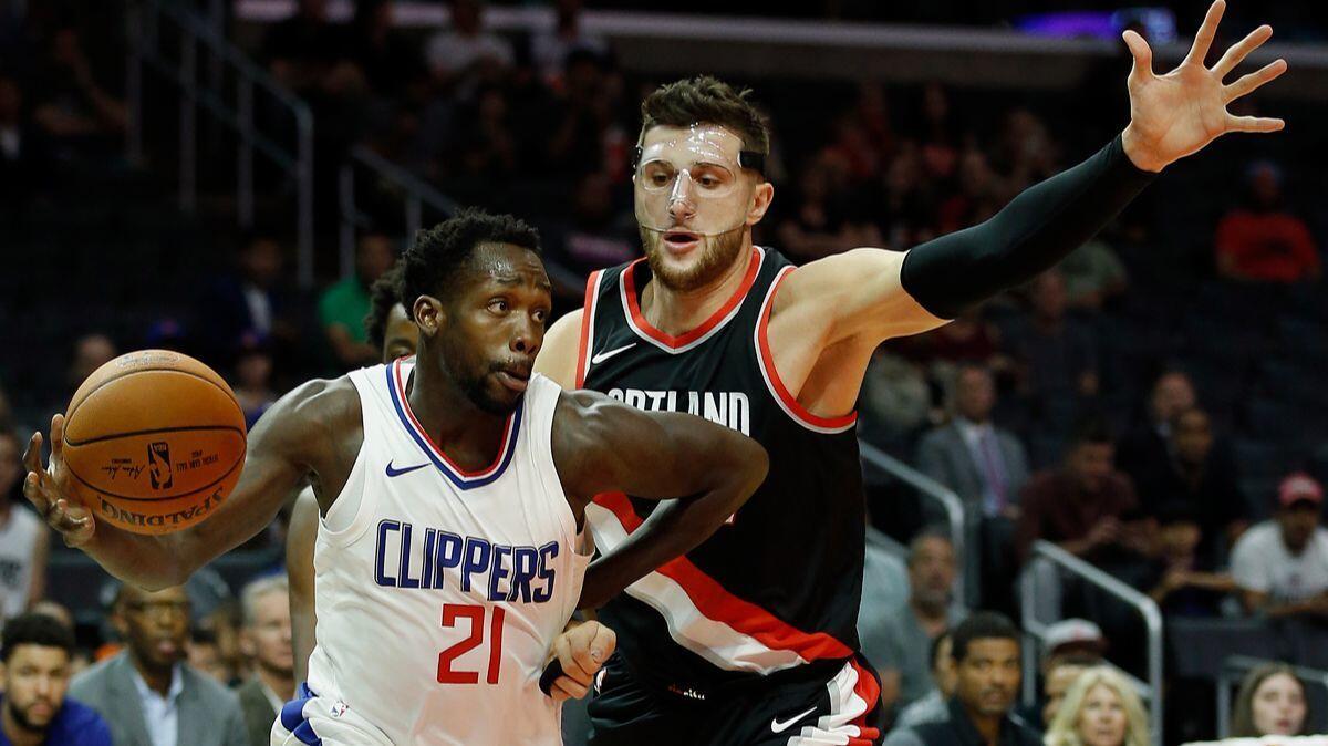 Clippers guard Patrick Beverley, left, drives around Portland Trail Blazers center Jusuf Nurkic during the first half of a preseason game on Sunday.