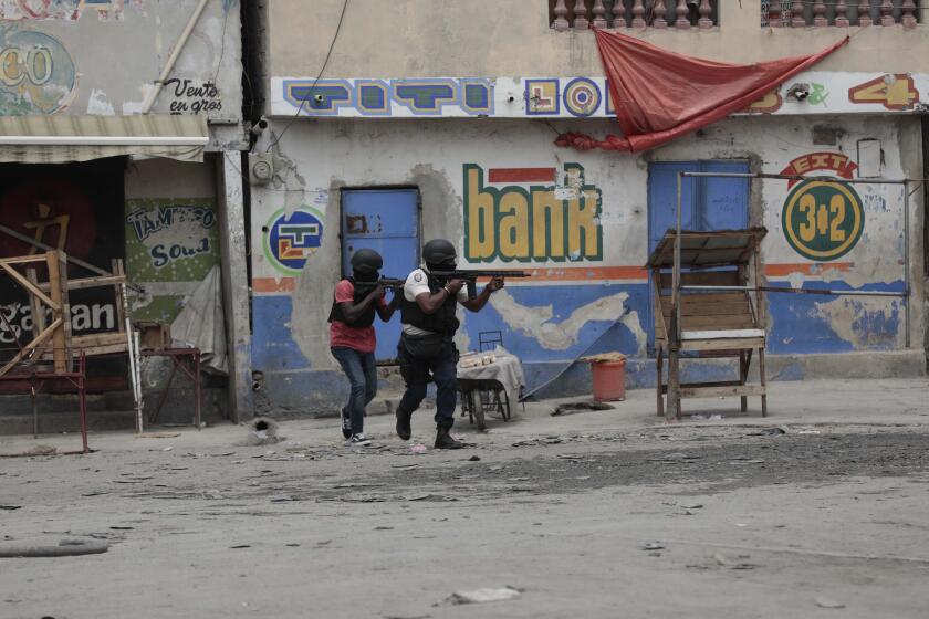 Agentes de policía se resguardan durante un operativo antipandillas, el martes 25 de abril de 2023, en el vecindario Portail, en Puerto Príncipe, Haití. (AP Foto/Odelyn Joseph)