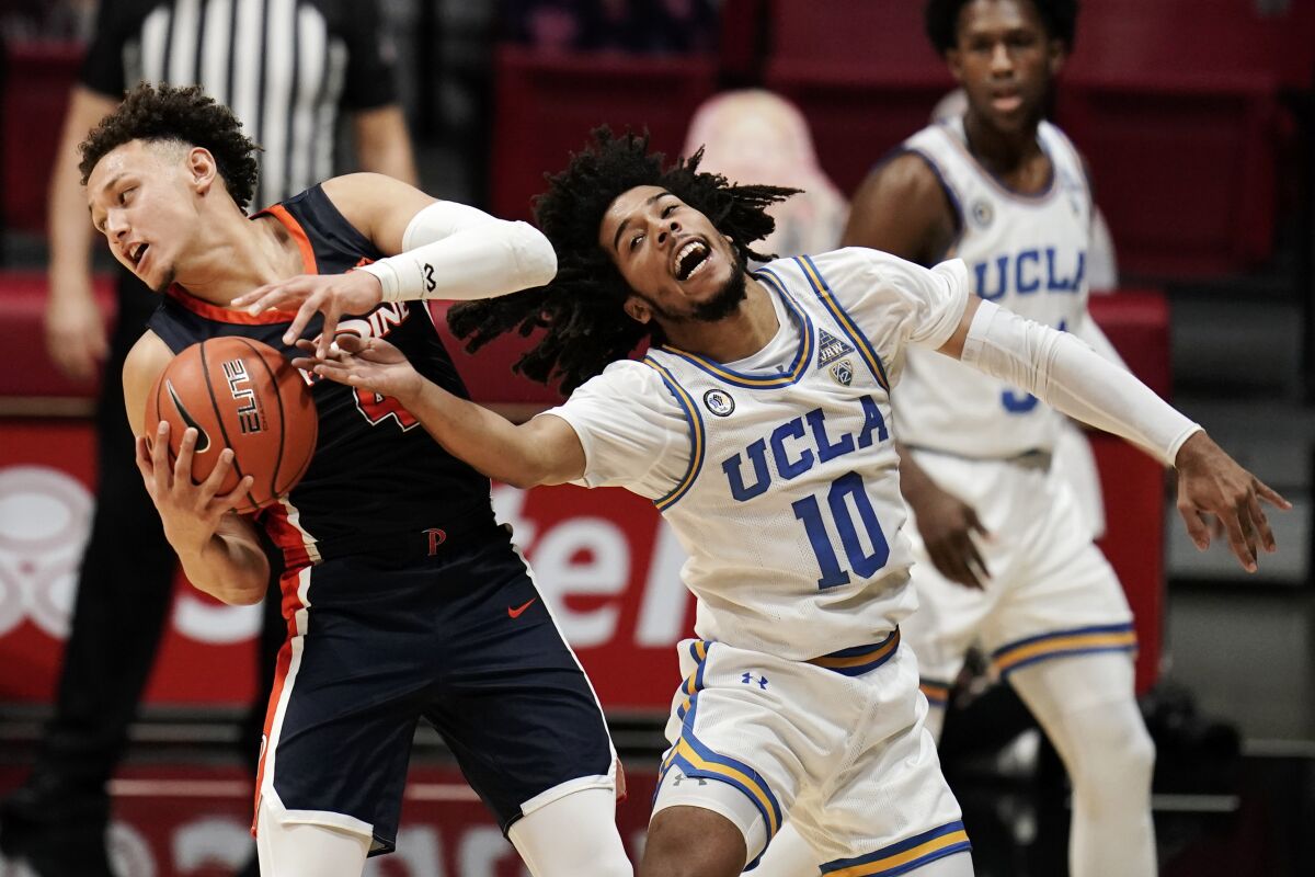 UCLA guard Tyger Campbell loses the ball to Pepperdine guard Colbey Ross.