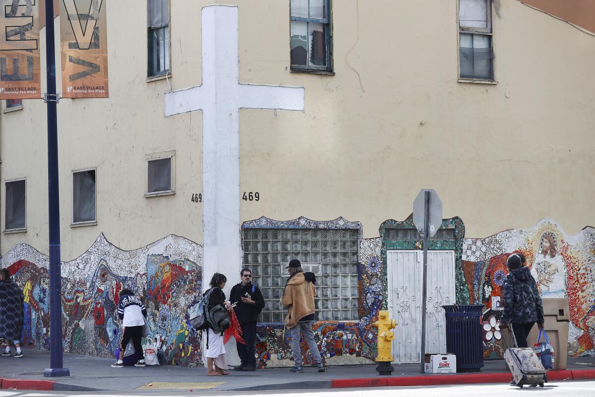 Homeless people stand outside the God's Extended Hand ministry.