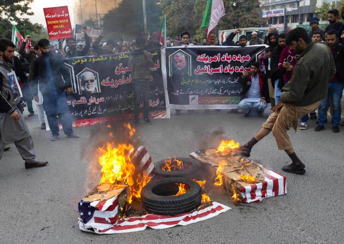 Unas personas queman banderas estadounidenses durante una protesta por el ataque de Estados Unidos que provocó la muerte del general iraní Qassem Soleimani, en Islamabad, Pakistán, el viernes 3 de enero de 2020. (AP Foto/B.K. Bangash)