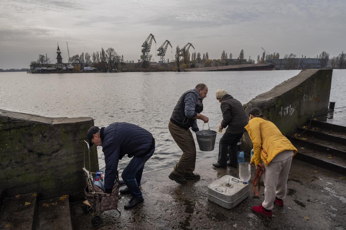 Kherson residents collect water from the Dnipro river bank.