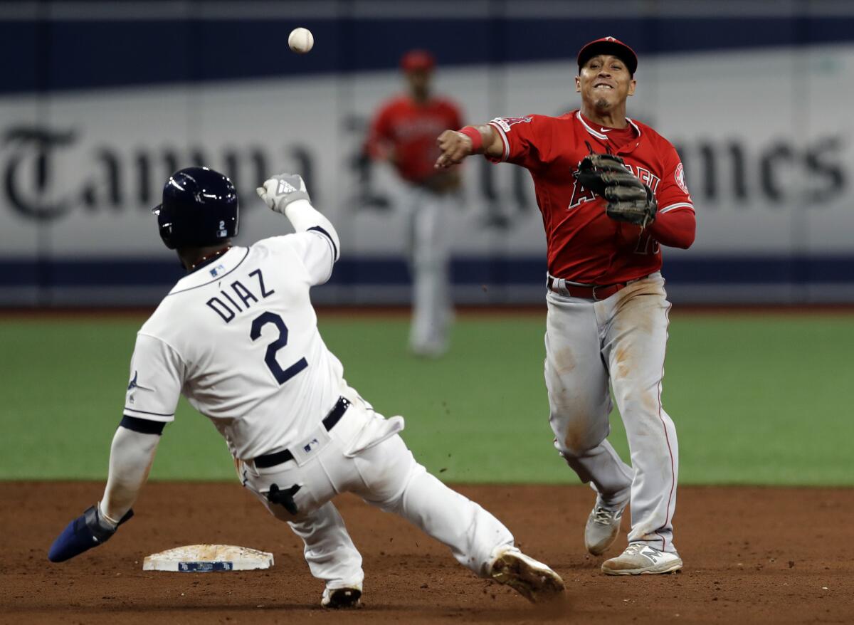 Angels shortstop Wilfredo Tovar throws to first after forcing out Tampa Bay Rays' Yandy Diaz (2) at second base, in time to turn a double play on Ji-Man Choi during the eighth inning on Friday.