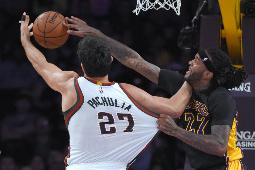 Lakers center Jordan Hill battles Bucks center Zaza Pachulia for a rebound in the first half.