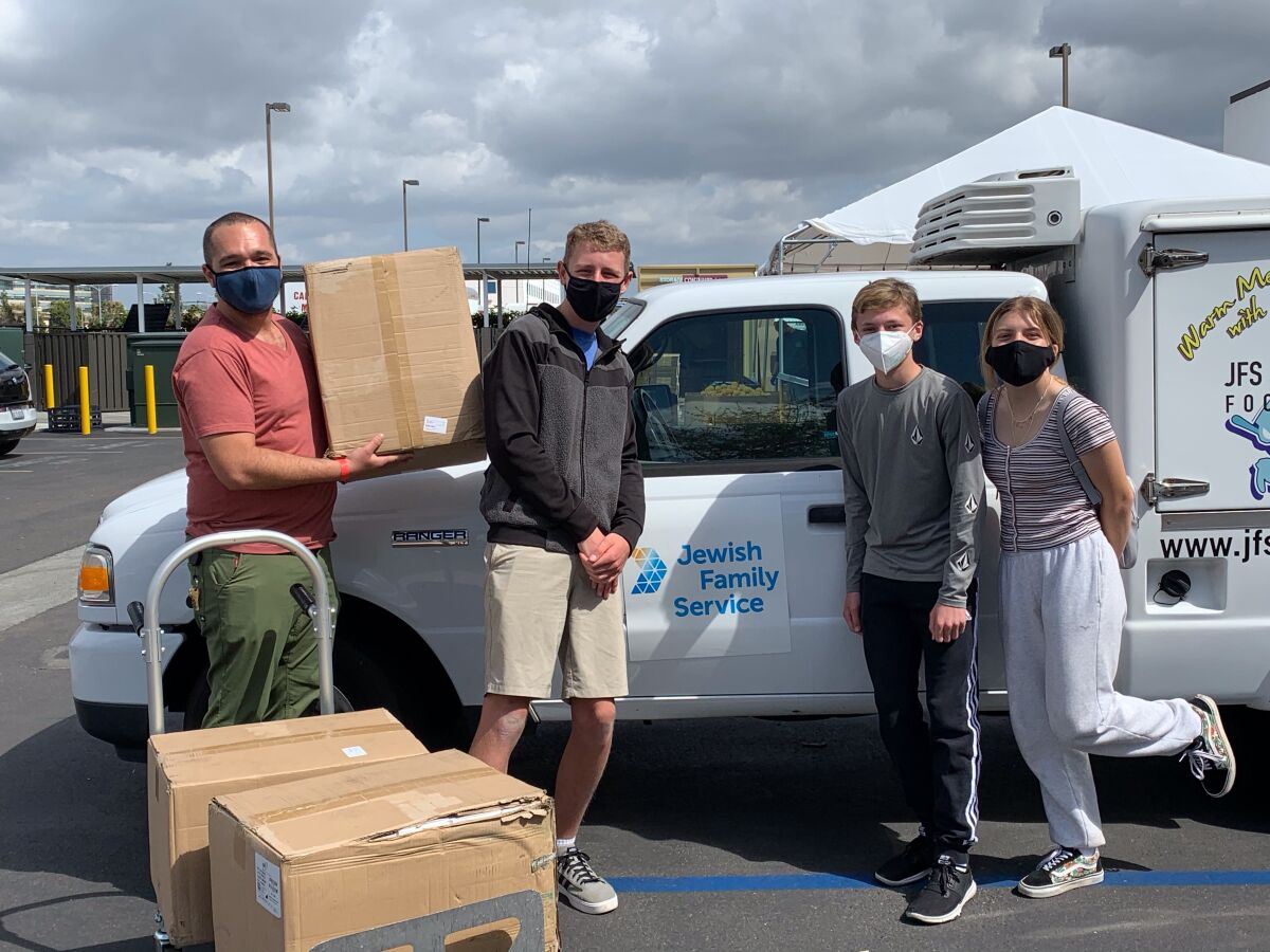 Ezra Granet (second from right) recently made a mask donation to Jewish Family Services.
