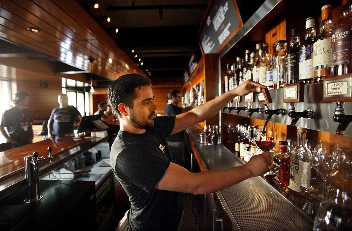 Bartender Erik Solis pours a glass of Holus Bolus Syrah, one of several wines offered on tap at Father's Office, a gastropub in Culver City.
