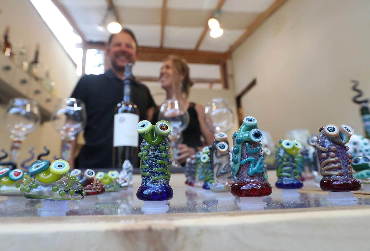 Alex Fritz and wife Nicole proudly stand behind his gecko glass sculptures during the 2022 Sawdust Festival preview night.