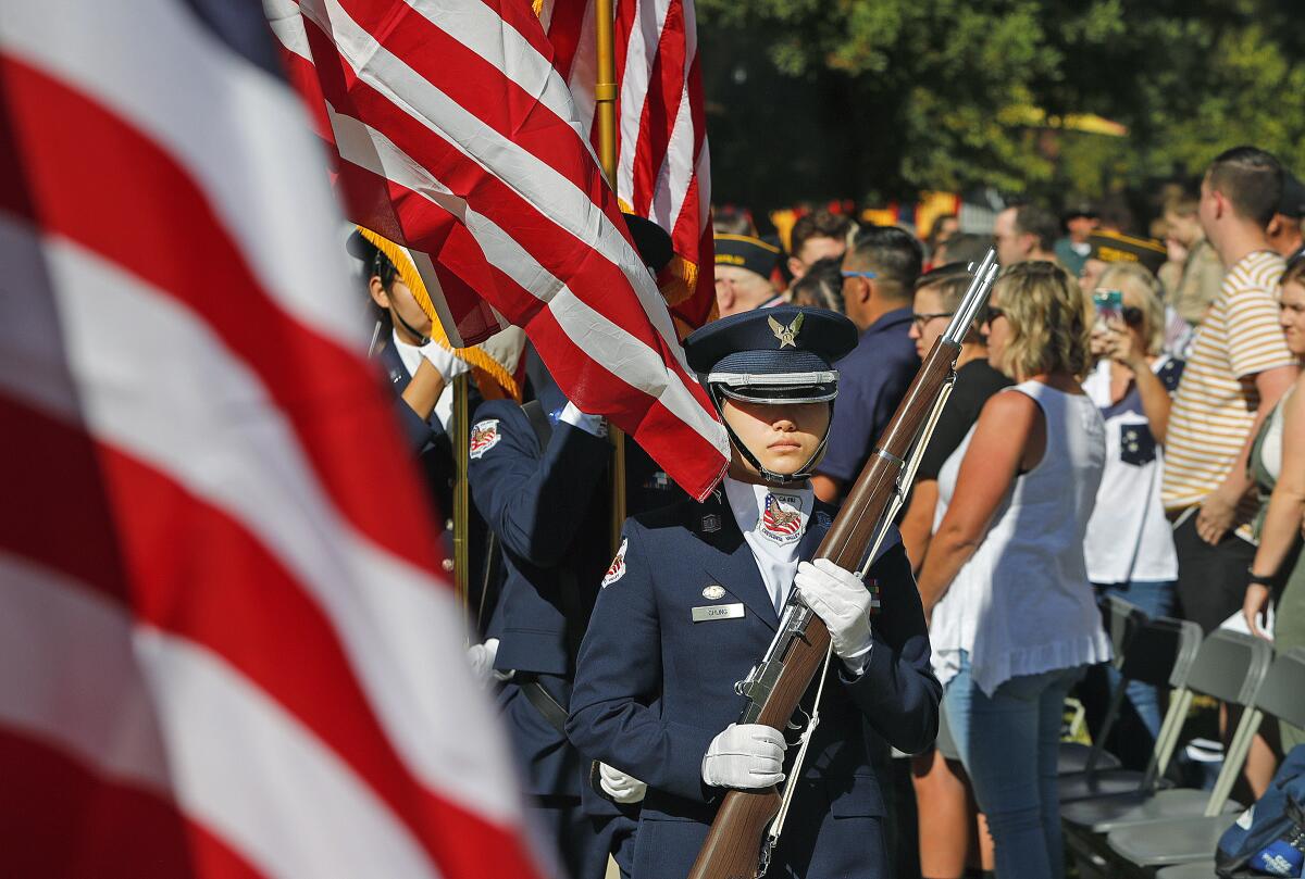 Members of the Crescenta Valley High School Junior ROTC color guard exit after the Pledge of Allegiance during an annual event to recognize local veterans at Two Strike Park in La Crescenta on Veterans on Monday.