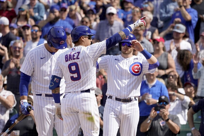 Chicago Cubs' Javier Baez (9) points to the fans as he celebrates his two-run home run off San Diego Padres relief pitcher Miguel Diaz with Anthony Rizzo, left, and Ian Happ in the seventh inning of a baseball game Wednesday, June 2, 2021, in Chicago. (AP Photo/Charles Rex Arbogast)
