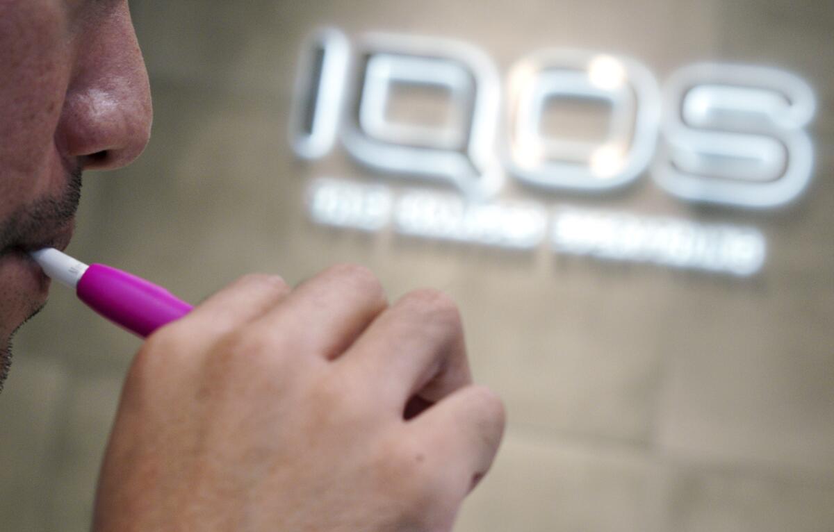 A visitor tries out an iQOS at a store in Tokyo in 2018.