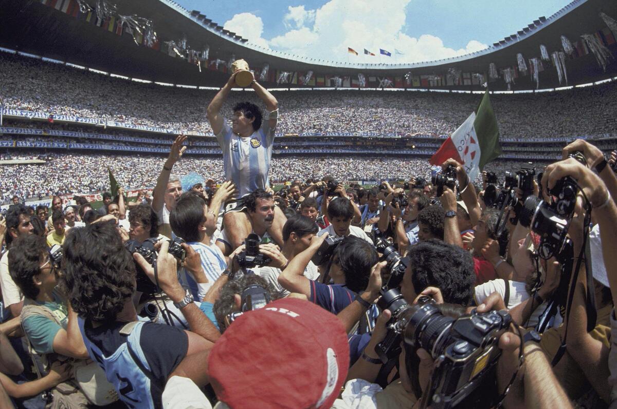 FILE - In this June 29, 1986 file photo, Diego Maradona holds up his team's trophy 