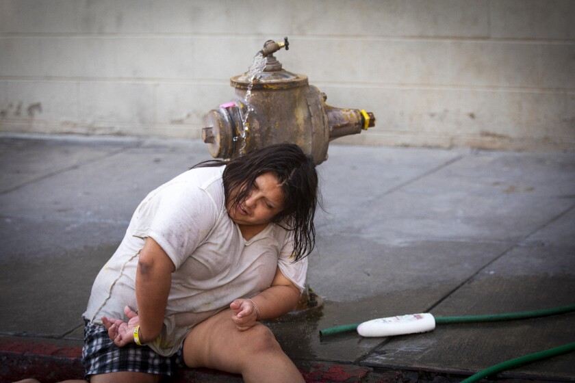 Monica Ruiz, 32, cools down in the water from a fire hydrant on Crocker Street in downtown L.A. on Sept. 6.
