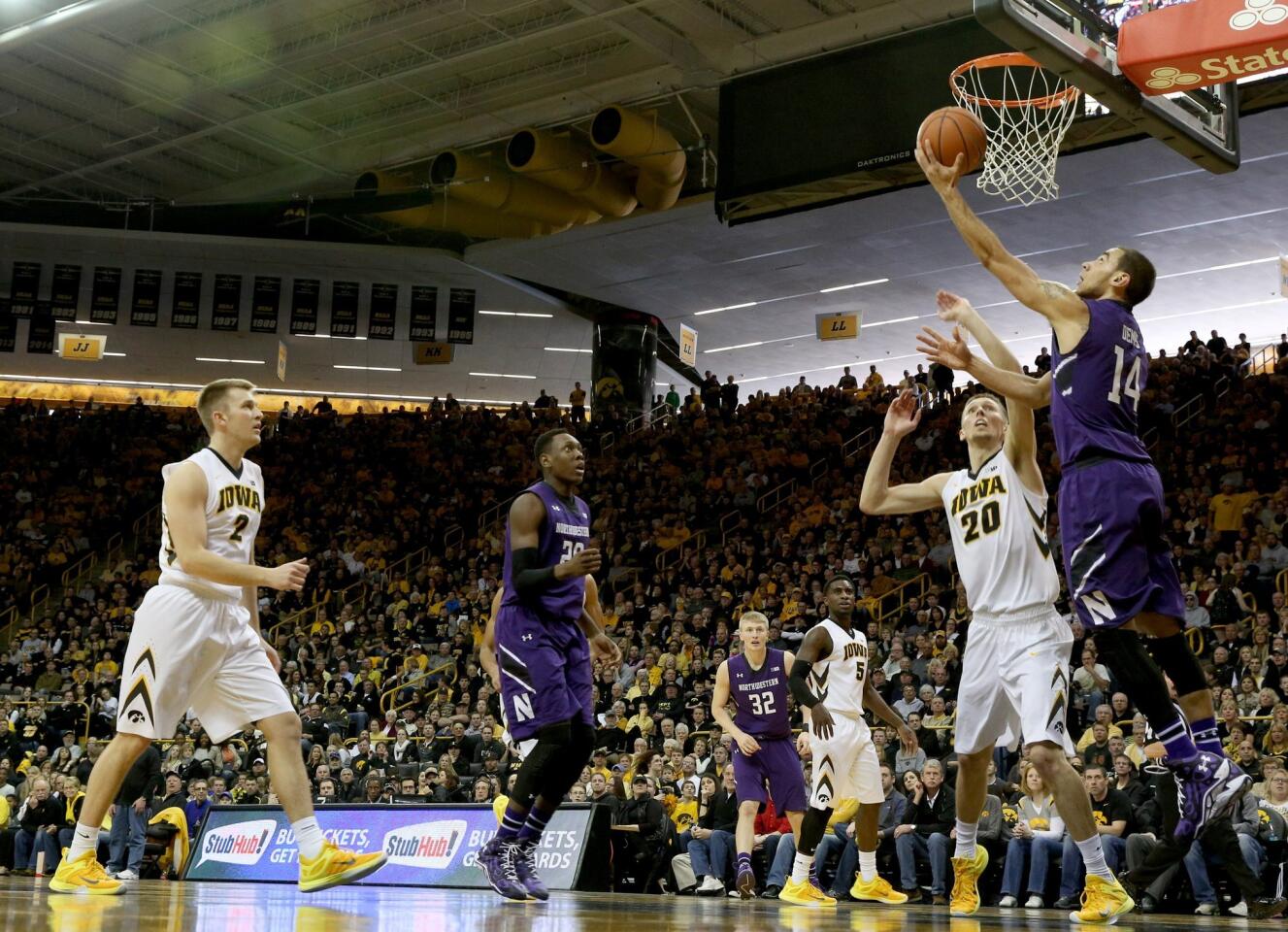 Northwestern guard Tre Demps puts in a reverse lay up past Iowa forward Jarrod Uthoff during the second half.