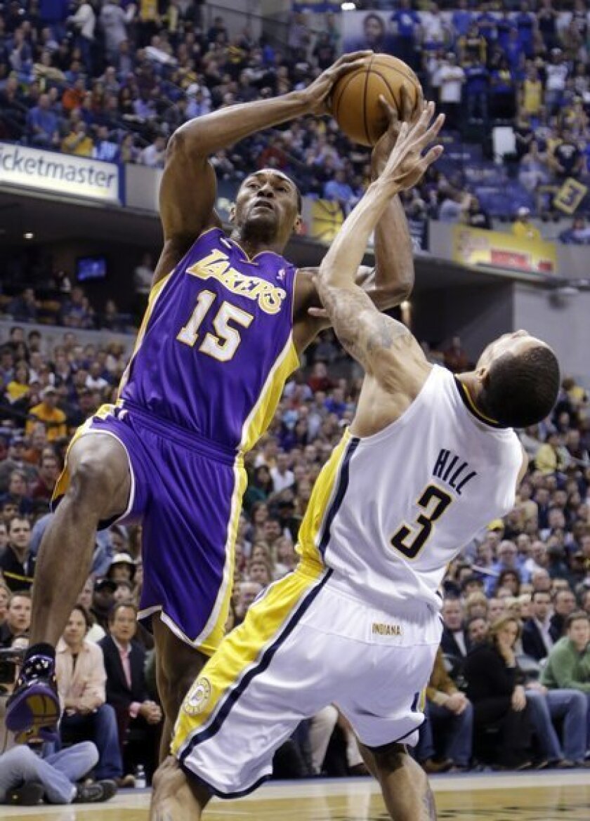 Pacers guard George Hill (3) takes a charge from Lakers forward Metta World Peace during the first half Friday night.
