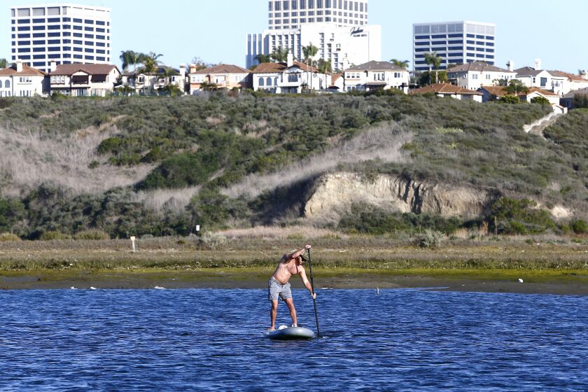 A paddle boarder explores Newport Bay at the Newport Aquatic Center in Newport Beach on Thursday.