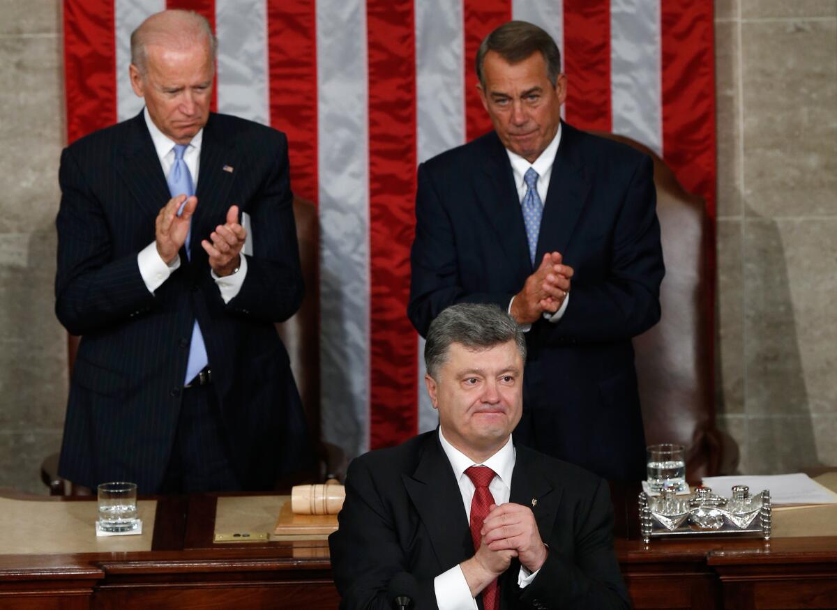 Ukrainian President Petro Poroshenko, flanked by Vice President Joe Biden and House Speaker John Boehner, acknowledges a standing ovation Thursday after addressing a joint meeting of Congress.