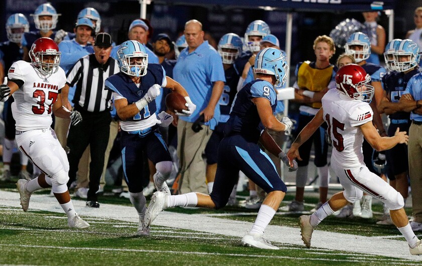 A Corona del Mar football player runs for a touchdown in 2019.