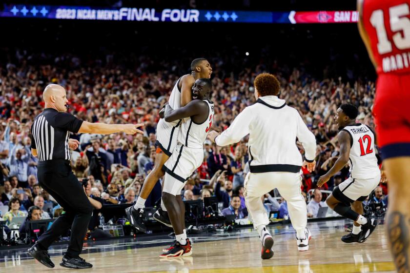 Houston, TX - April 1: San Diego State Aztecs guard Lamont Butler is embraced by teammate Aguek Arop after hitting the game winning shot at the buzzer to send the team to the national championship during the semifinal round of the 2023 NCAA Men's Basketball Tournament played between the San Diego State Aztecs and the Florida Atlantic Owls at NRG Stadium on Saturday, April 1, 2023 in Houston, TX. (K.C. Alfred / The San Diego Union-Tribune)