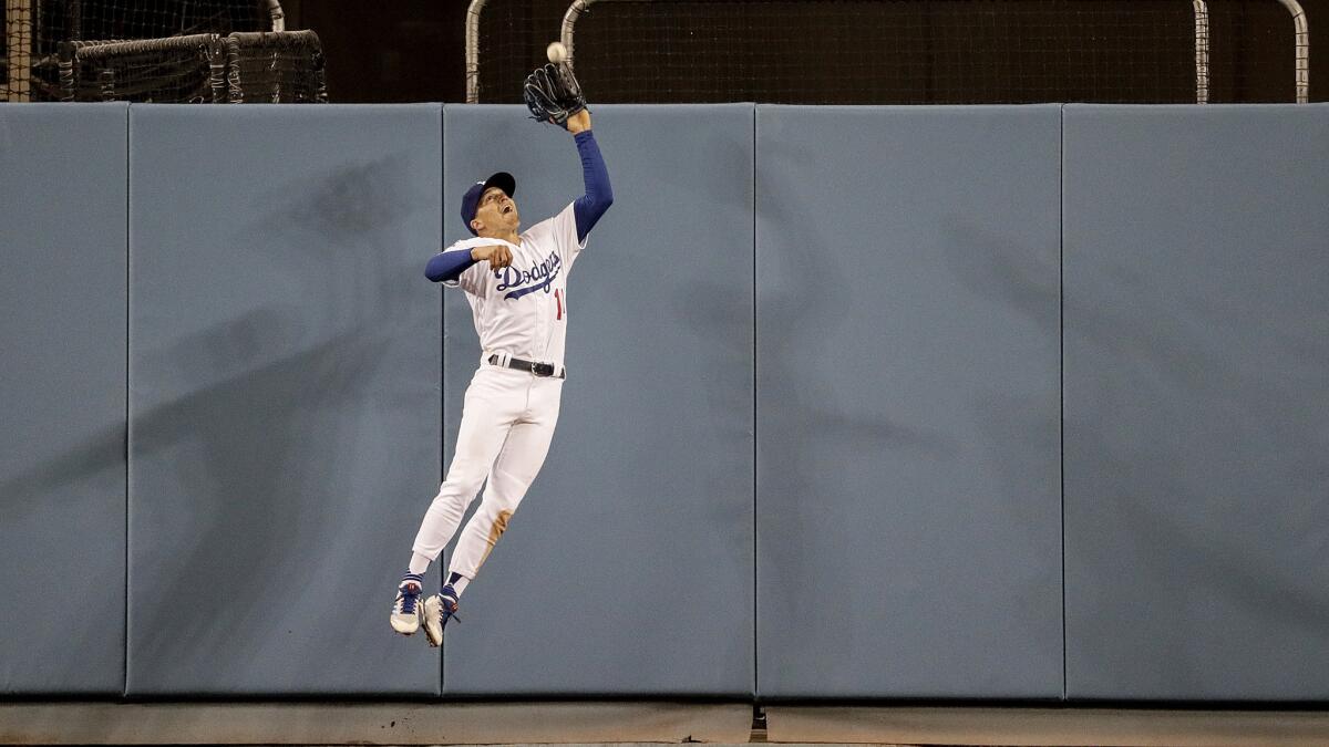 Dodgers centerfielder Enrique Hernandez makes a leaping catch of a ninth inning drive by Giants first baseman Brandon Belt.