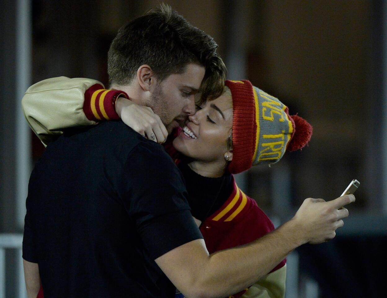 Patrick Schwarzenegger and Miley Cyrus made headlines when they engaged in some PDA during the USC Trojans' 38-30 victory over UC Berkeley at the L.A. Memorial Coliseum on Nov. 13, 2014.