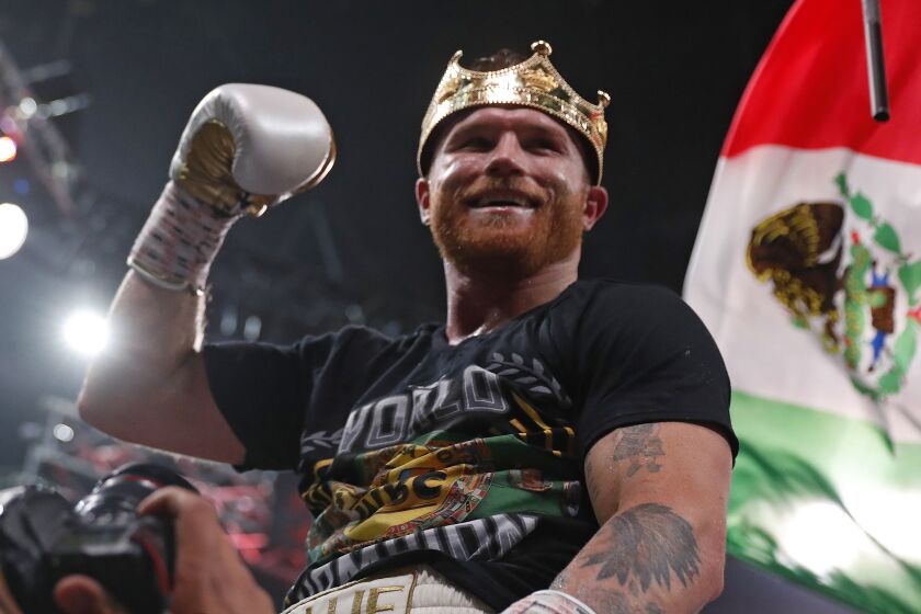 Canelo Alvarez, of Mexico, celebrates after defeating Caleb Plant by in a super middleweight title.