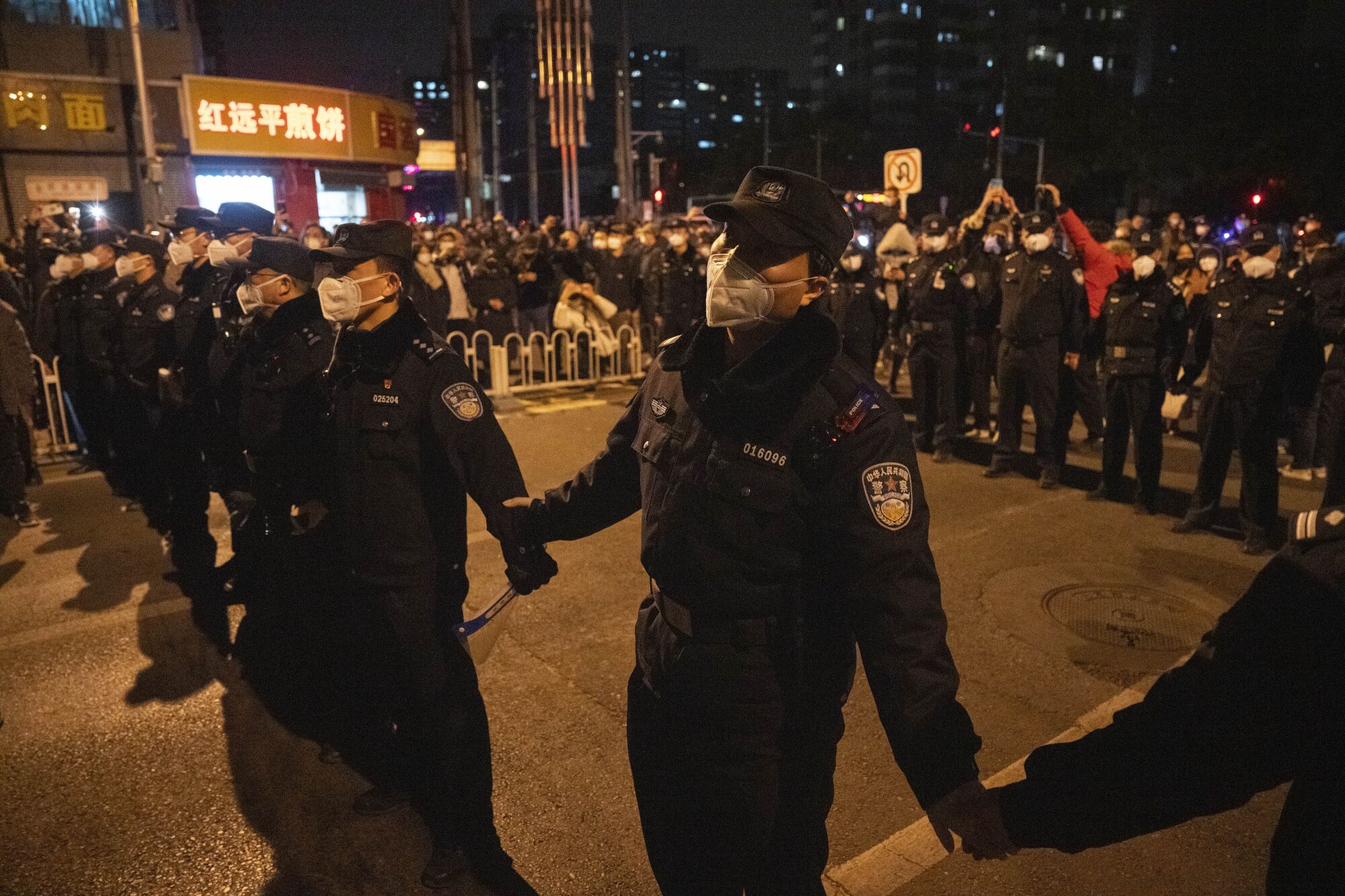 Chinese policemen form a line to stop protesters marching 