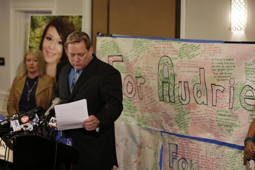 Audrie Pott's father, Larry Pott, stands beside her mother, Sheila Pott, and reads a statement. "These boys distributed the picture to humiliate and bully my daughter," Sheila Pott said.