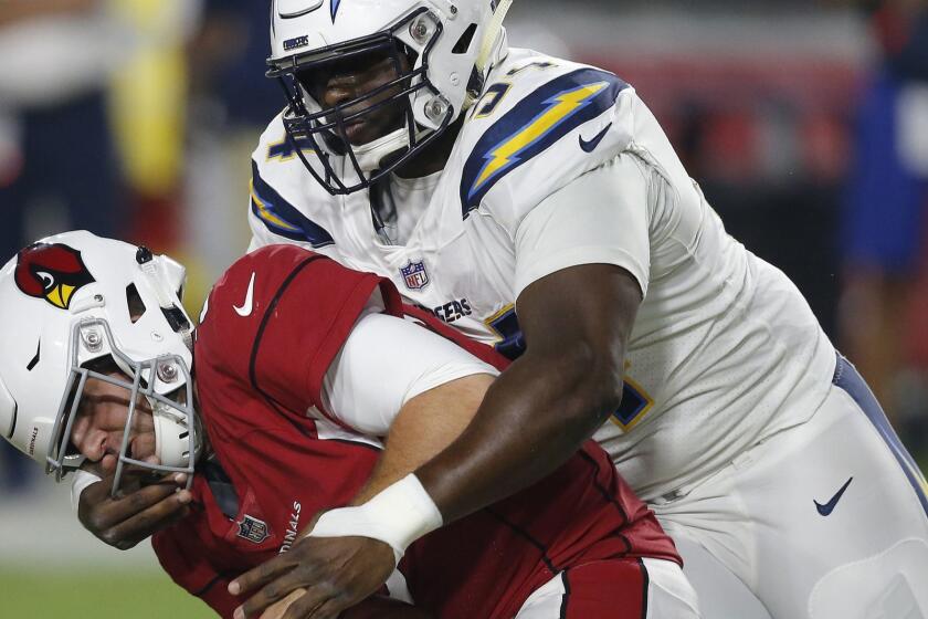 Los Angeles Chargers defensive tackle Corey Liuget (94) grabs the face mask of Arizona Cardinals quarterback Josh Rosen (3) for a 15-yard penalty during the first half of a preseason NFL football game, Saturday, Aug. 11, 2018, in Glendale, Ariz. (AP Photo/Ross D. Franklin)