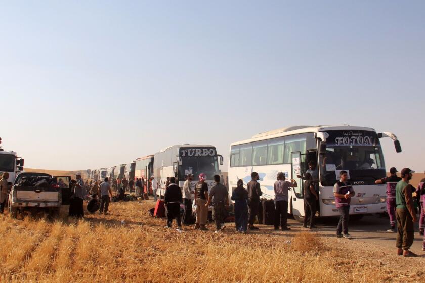 Syrian civilians and fighters who were evacuated from northeastern Lebanon gather near buses after crossing into the rebel-held area of Al-Saan in the central Syrian Hama province on August 3, 2017. Nearly 8,000 Syrian refugees and fighters from Lebanon arrived in central Syria as part of a ceasefire deal that also saw five Hezbollah fighters released, a monitor and the Shiite militant group said / AFP PHOTO / Omar haj kadourOMAR HAJ KADOUR/AFP/Getty Images ** OUTS - ELSENT, FPG, CM - OUTS * NM, PH, VA if sourced by CT, LA or MoD **
