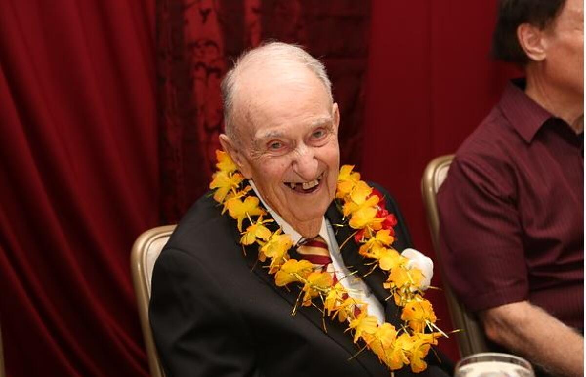 Dennis Murphy wearing a lei with a business suit