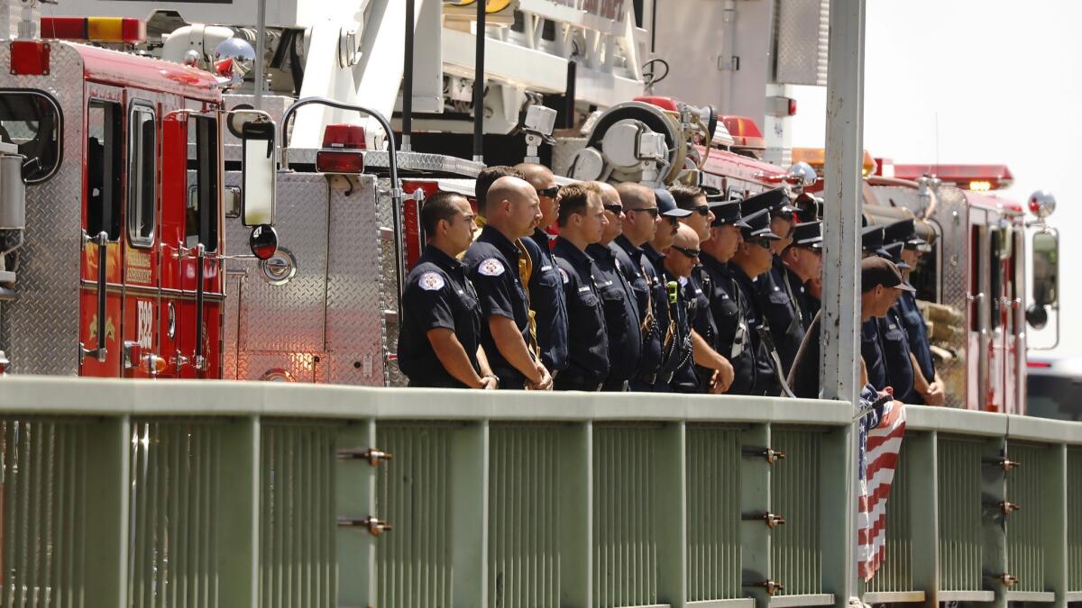 Long Beach Fire Department firefighters gather at West Willow Street to salute Capt. Dave Rosa.