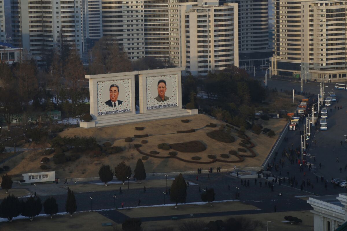 FILE - Portraits of late North Korean leaders Kim Il Sung and Kim Jong Il sit in downtown Pyongyang, North Korea on Dec. 19, 2018. North Korea is continuing to steal hundreds of millions of dollars from financial institutions and cryptocurrency firms and exchanges, illicit money that is an important source of funding for its nuclear and missile programs, U.N. experts said in a report quoting cyber specialists. (AP Photo/Dita Alangkara, File)