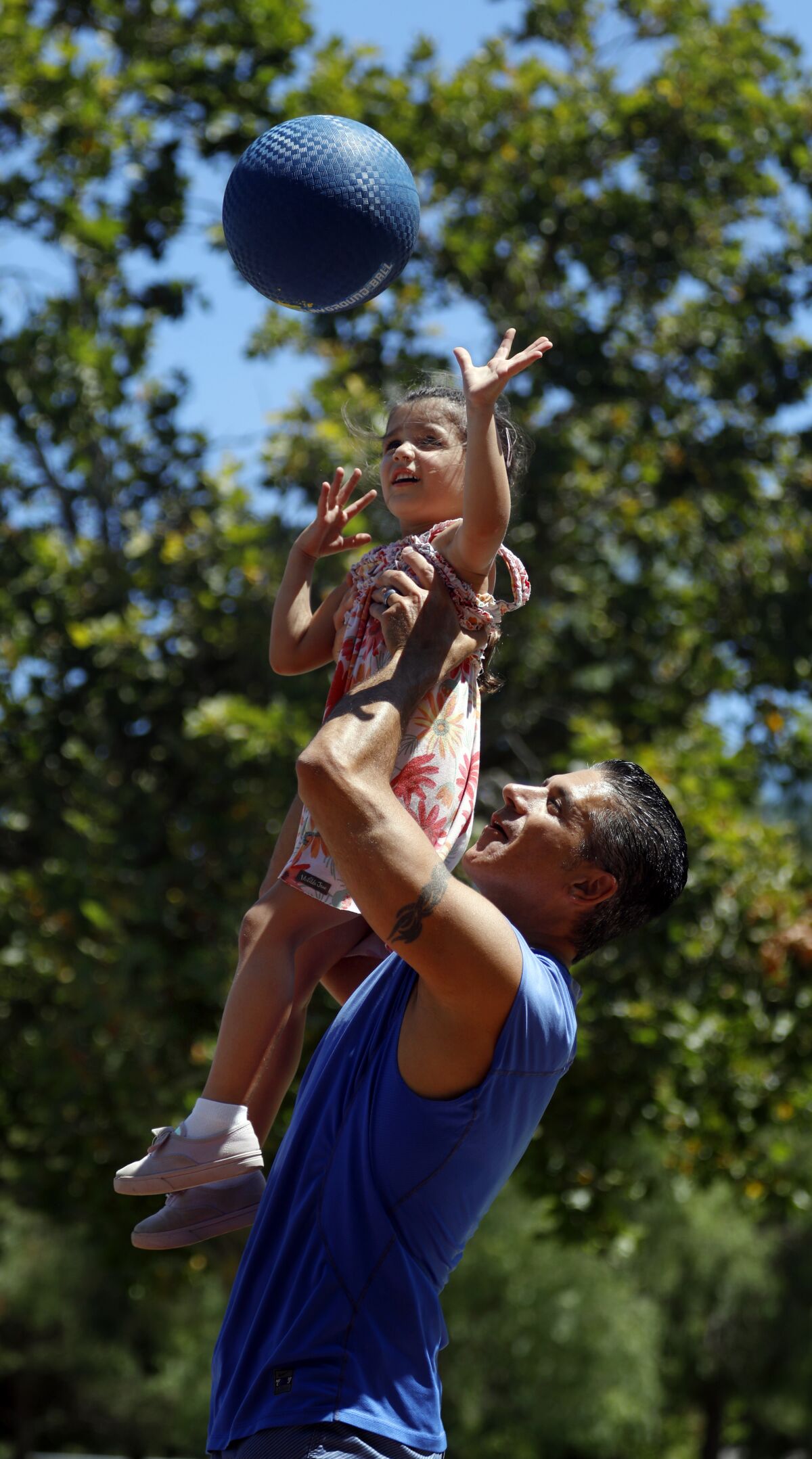 Jon Hatami helps daughter Lindsey Beth, 4, play basketball.