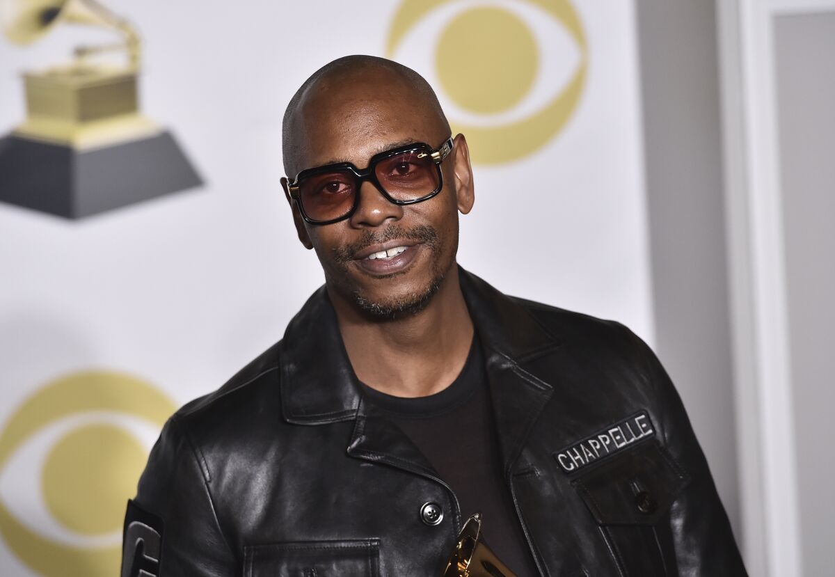 FILE - In this Jan. 28, 2018 file photo, Dave Chappelle poses in the press room with the best comedy album award for "The Age of Spin" and "Deep in the Heart of Texas" at the 60th annual Grammy Awards in New York. Netflix said Friday, Oct. 15, 2021 that it had fired an employee for disclosing confidential financial information about what it paid for Dave Chappelle’s comedy special “The Closer," which some condemned as being transphobic. (Photo by Charles Sykes/Invision/AP, File)