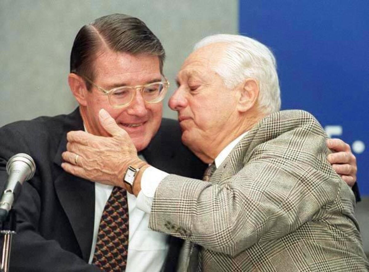 Tommy Lasorda hugs then-Dodgers owner Peter O'Malley.
