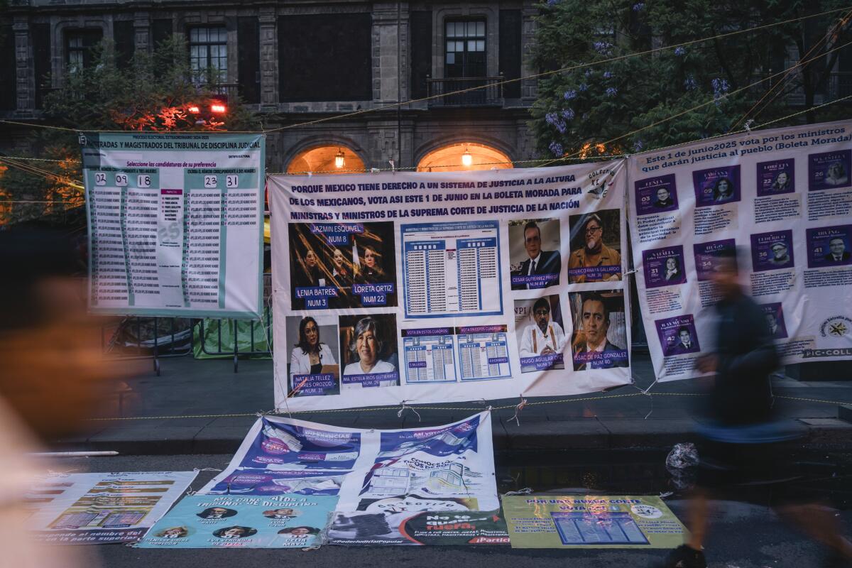 People walk through the main square where posters were installed