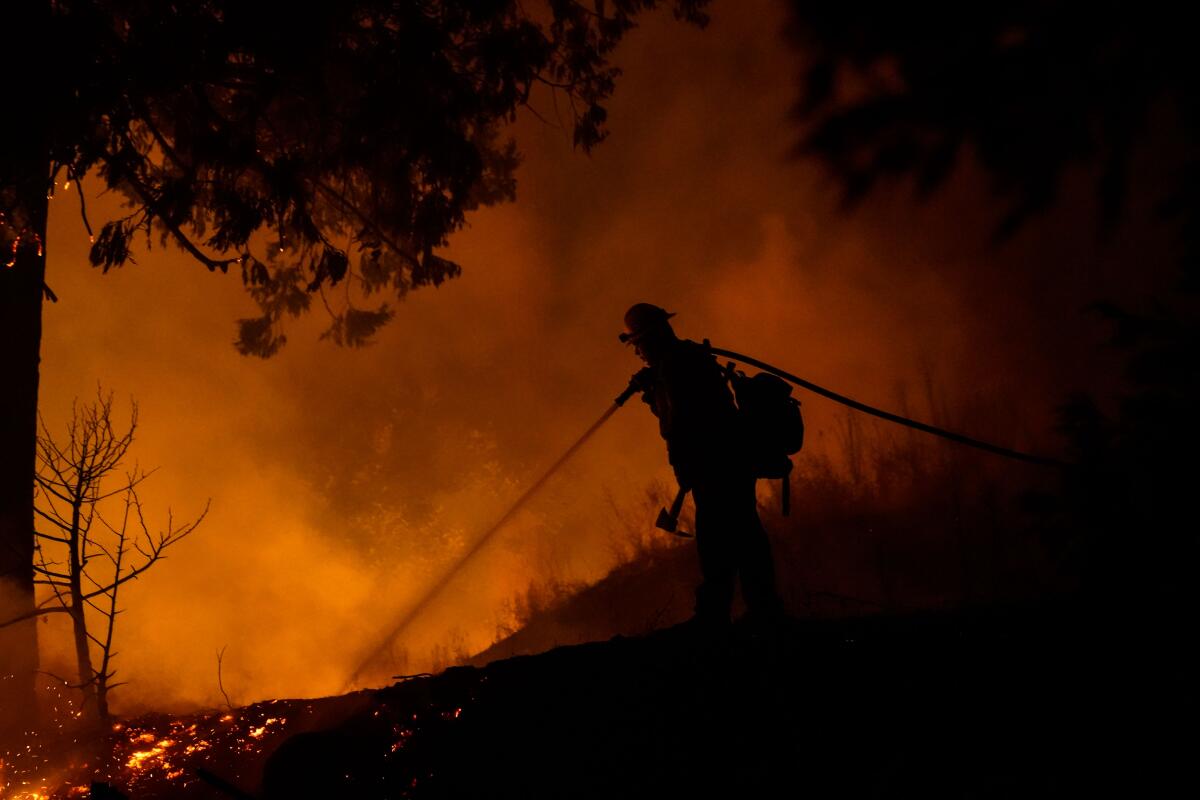 A firefighter battles the Creek Fire in Big Creek, CA.