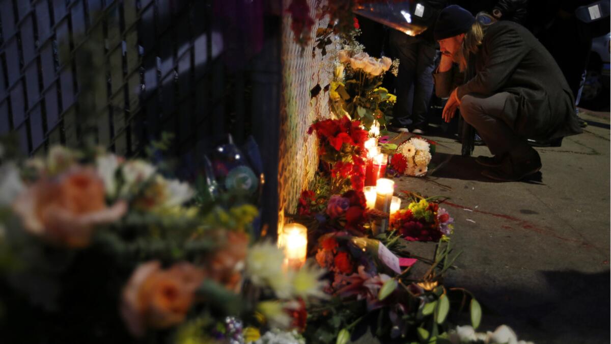 A man who identified himself as Ben P. reads cards on Sunday at a memorial near the site of the blaze.