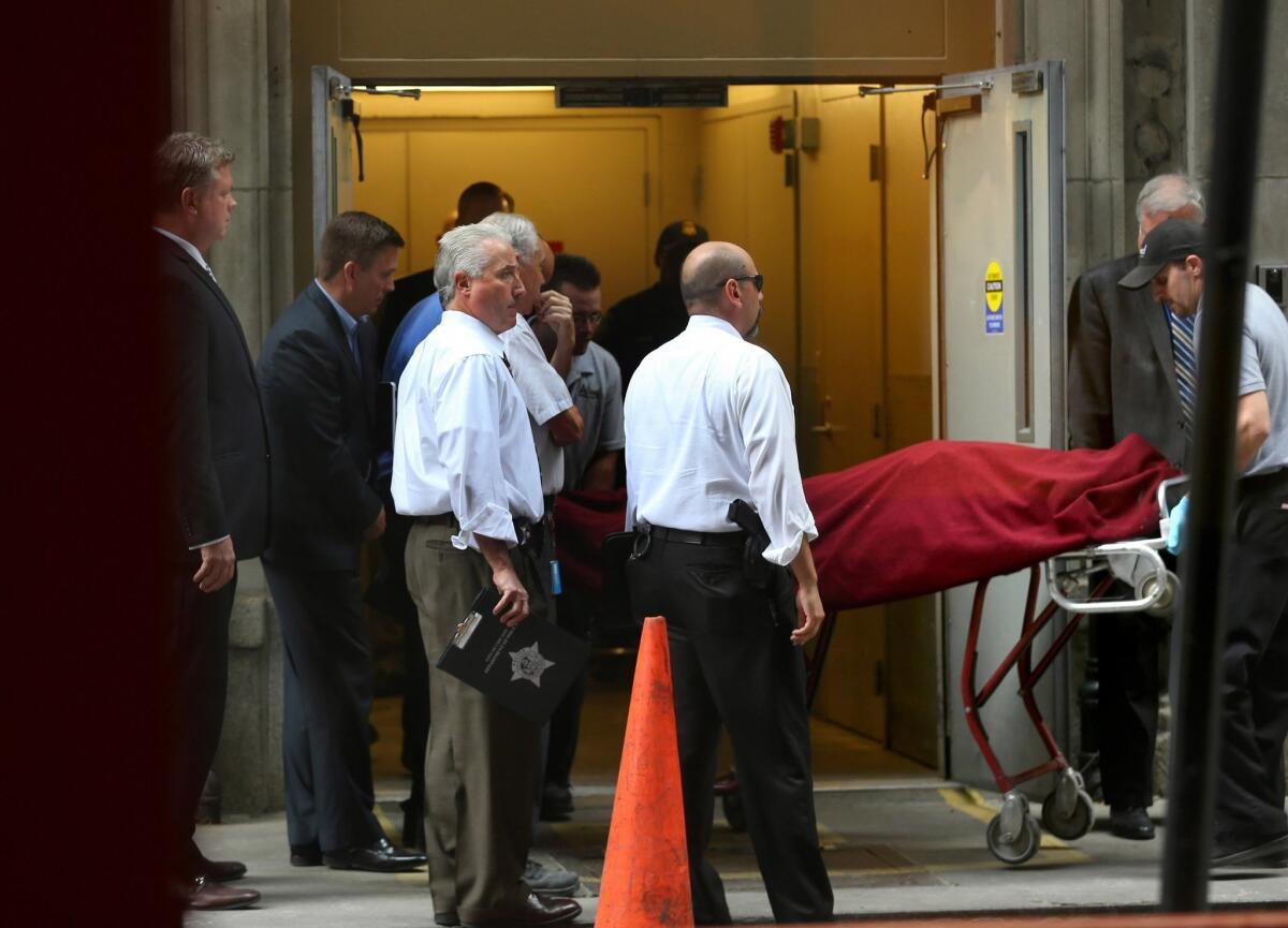 The body of the alleged shooter is taken out a side door Thursday of a Bank of America building in downtown Chicago.