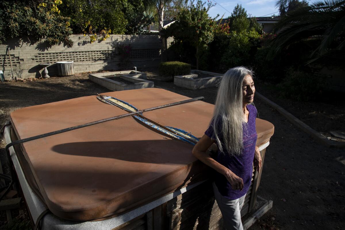 A woman leaning against a Jacuzzi.