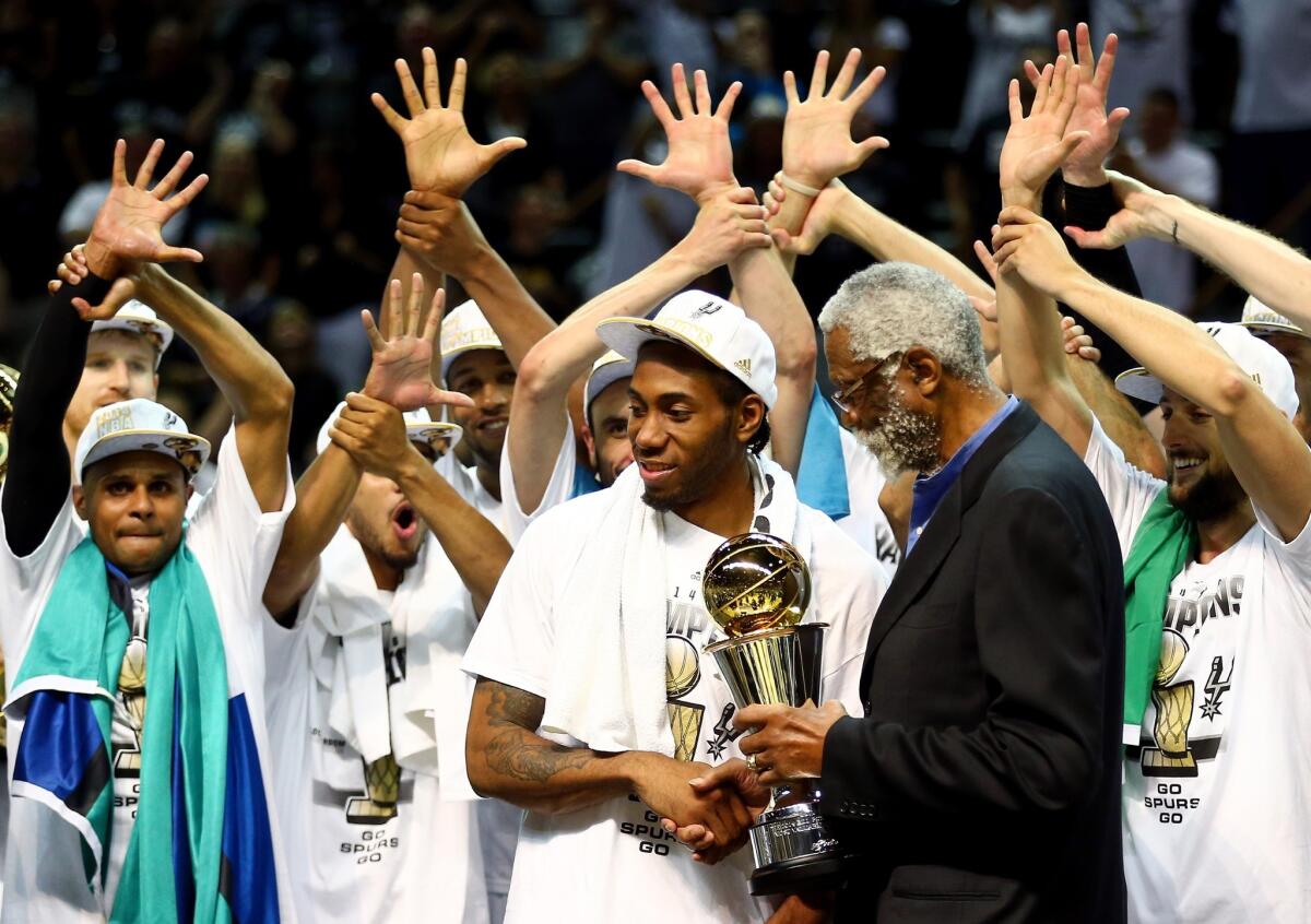 San Antonio's Kawhi Leonard recieves the NBA Finals most valuable player award from NBA legend Bill Russell after the Spurs defeated the Miami Heat in Game 5 on Sunday night.