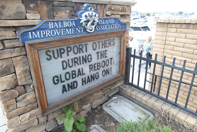 A sign outside the Balboa Island Improvement Assn. in Newport Beach reflects the coronavirus crisis.