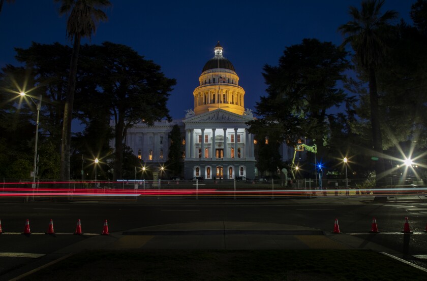 The California Capitol building at night, with the dome lighted.