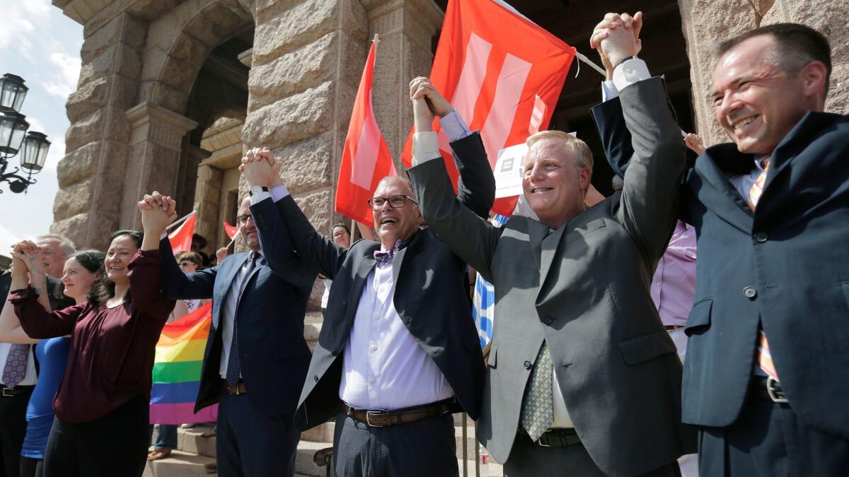 Jim Obergefell, the named plaintiff in the Obergefell v. Hodges Supreme Court case that legalized same sex marriage nationwide, center, forms a unity chain in Austin, Texas on June 29, 2015.