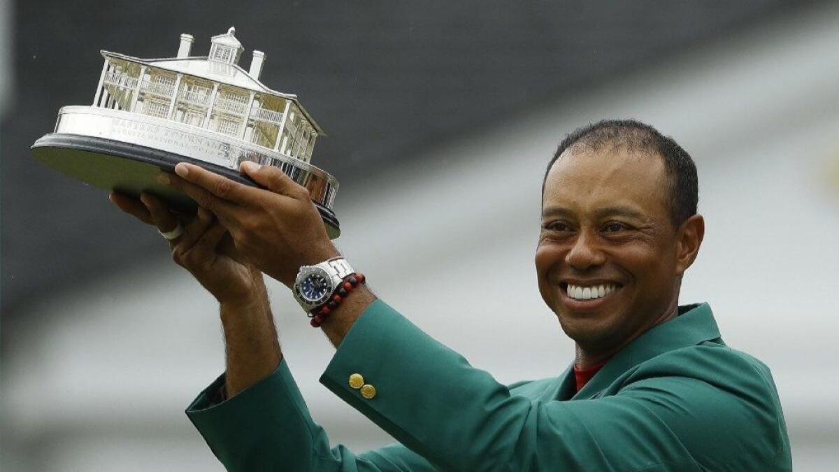 Tiger Woods wears his green jacket and holds the winning trophy after the final round of the Masters last month.