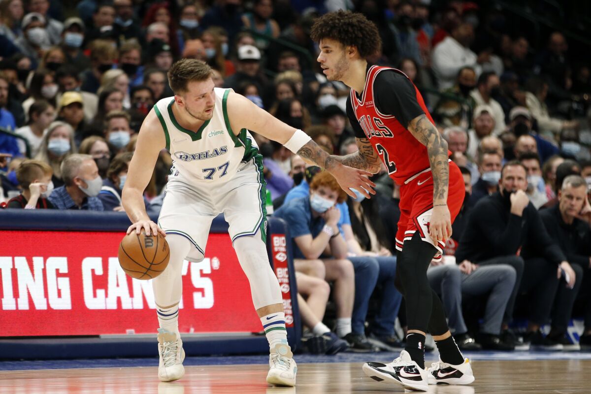 Dallas Mavericks guard Luka Doncic (77) is guarded by Chicago Bulls guard Lonzo Ball (2) in the first half of an NBA basketball game in Dallas, Sunday, Jan. 9, 2022. (AP Photo/Tim Heitman)