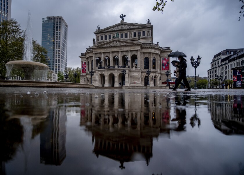 The Old Opera house is reflected in a puddle in Frankfurt, Germany, on a rainy Thursday, May 6, 2021. (AP Photo/Michael Probst)