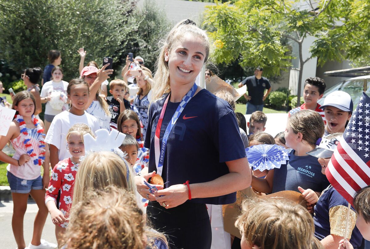 Olympic gold medalist Maddie Musselman is mobbed by neighborhood kids during a welcome home block party last year.